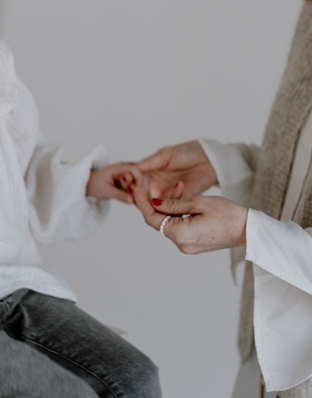 Zwei Frauen halten sich an den Händen